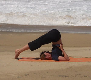 Halasana supported by hands, Copyright Yoga People, LLC