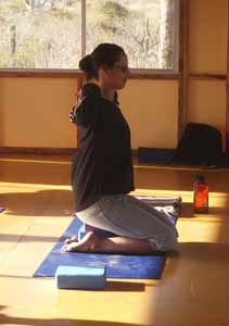 Yoga student sits on blocks