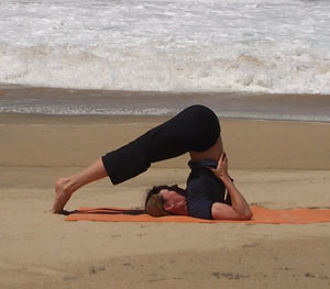 Halasana with support of arms and hands under back Halasana supported by hands, Copyright Yoga People, LLC